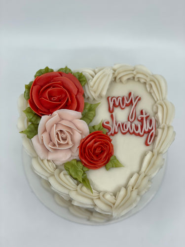 6 inch cake with pink and red roses and an inscription that say 