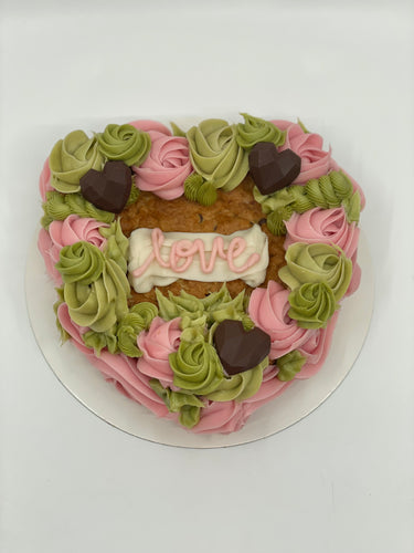 Chocolate Chip Cookie Cake with frosting flower design in pink and green with chocolate hearts.  Inscription reads 